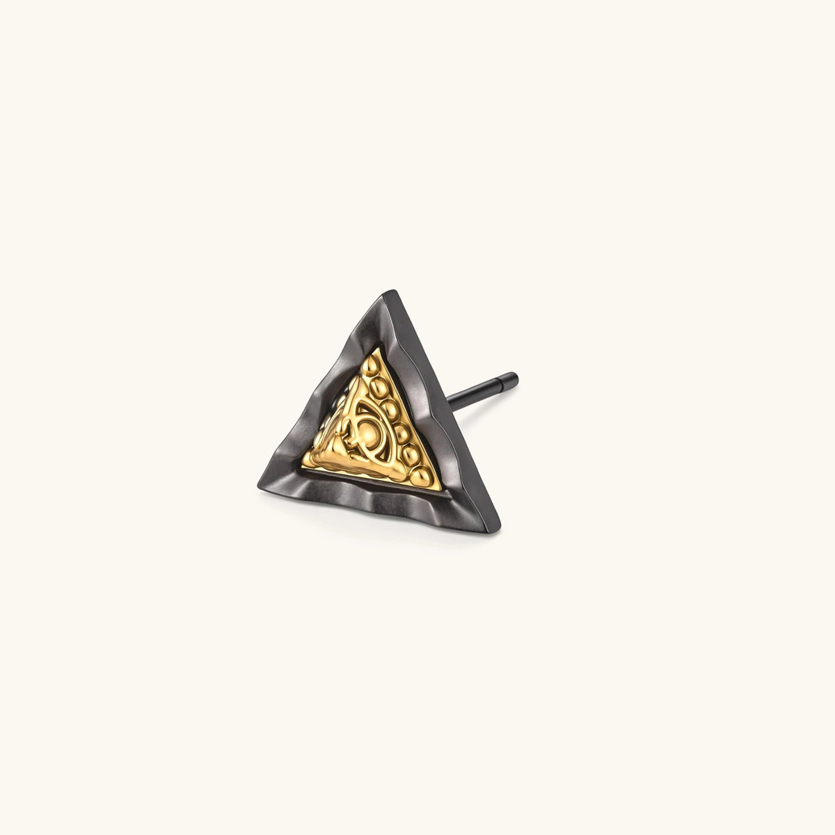 Single black triangle stud earring with a raised gold-tone center, beaded trim and eye motif on a cream background.